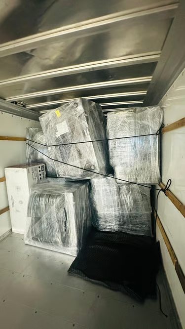 Shrink-wrapped furniture strapped inside a Chinook Movers truck